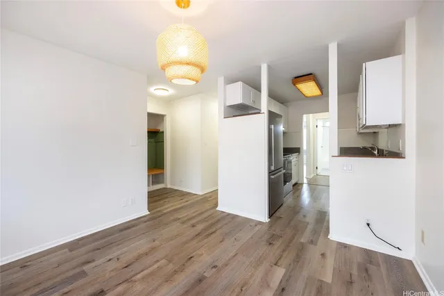 a view of a kitchen with wooden floor and electronic appliances