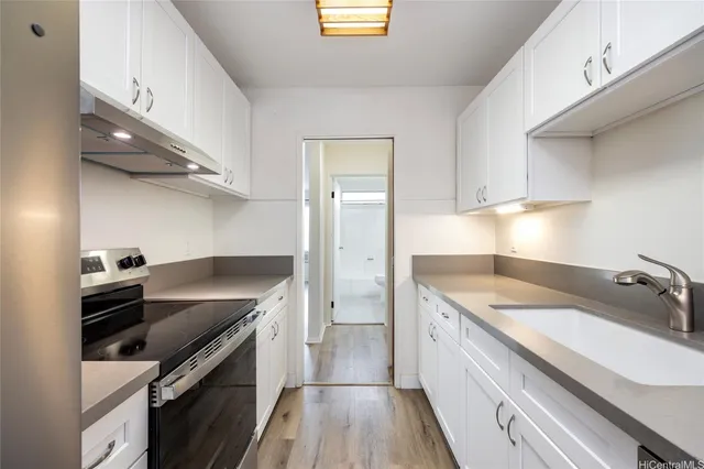 a kitchen with granite countertop a sink and a stove top oven