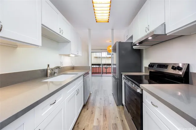 a kitchen with a sink a counter top space and stainless steel appliances