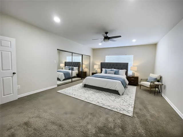 a bedroom with a large bed and a chandelier