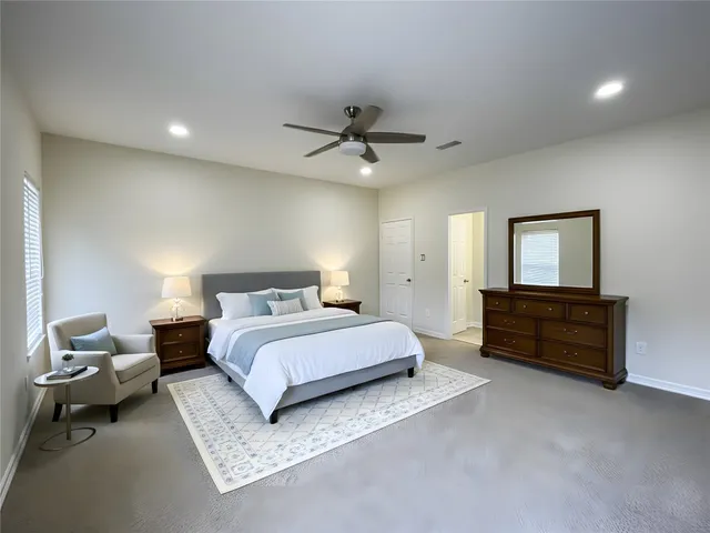 a spacious bedroom with a bed and a chandelier