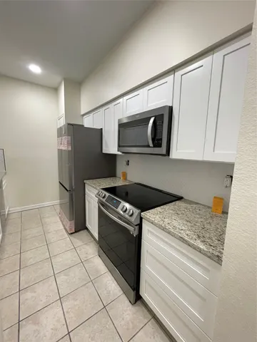 a kitchen with a stove a microwave and refrigerator