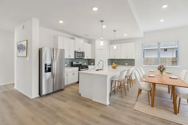 a kitchen with a refrigerator a table and chairs