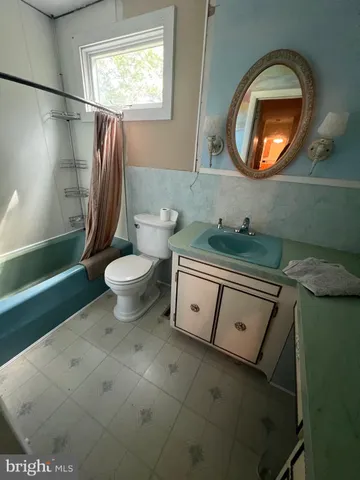 a bathroom with a toilet sink vanity and mirror