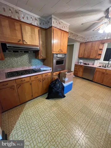 a kitchen with stainless steel appliances granite countertop a sink a stove and a wooden cabinets