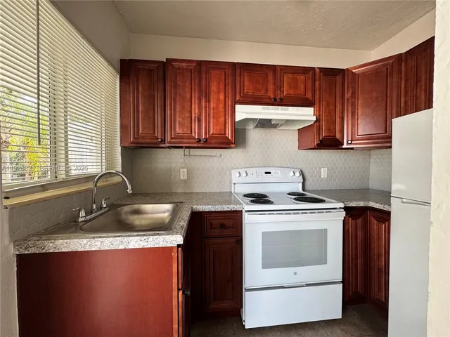 a kitchen with a sink stove top oven and cabinets