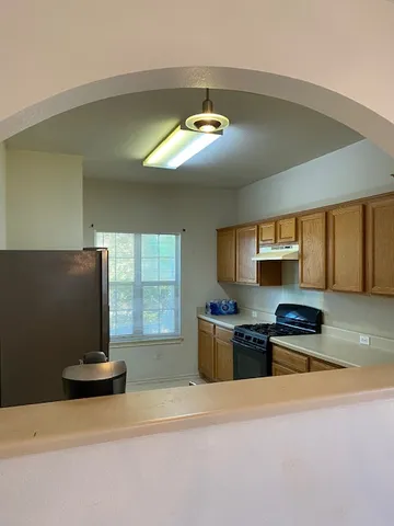 a kitchen with stainless steel appliances granite countertop a stove a sink and a refrigerator