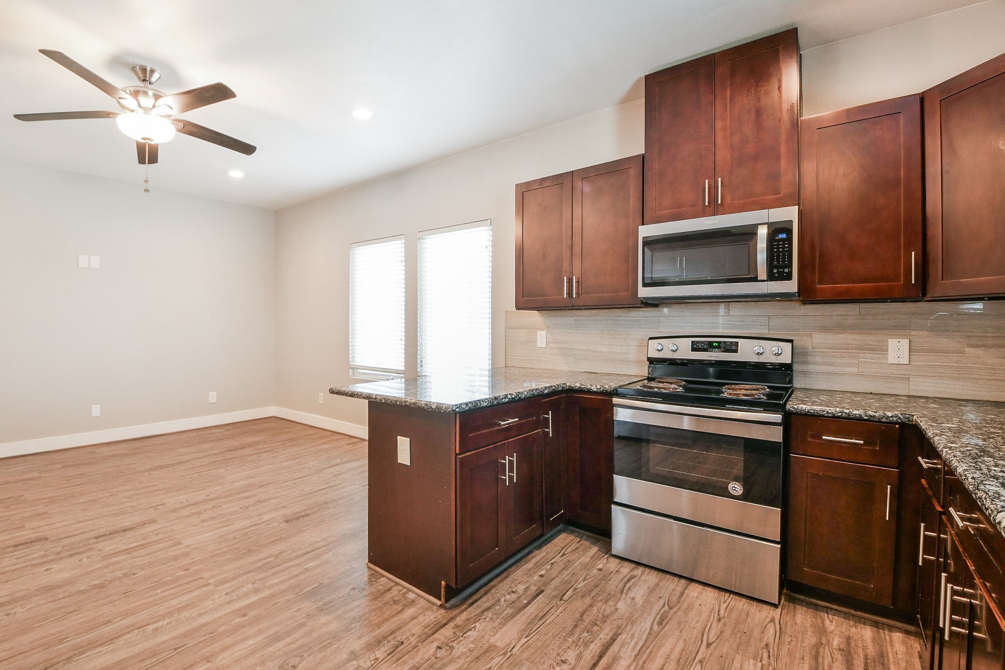 3249 Dixie Drive, Unit B Houston, TX 77021 - Photo 6 of 25 a kitchen with granite countertop wooden cabinets and stainless steel appliances