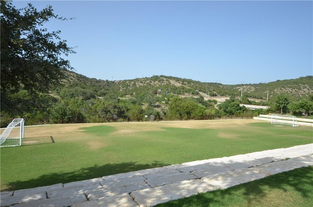 5629 Rio Chama Cove Austin, TX 78738 - Photo 30 of 34 Green recreational field set against a backdrop of rolling, tree-covered hills.