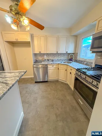 a kitchen with stainless steel appliances granite countertop a sink stove and granite counter tops