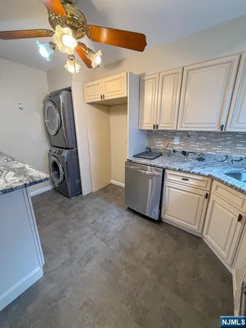 a view of a kitchen with a sink and dishwasher a stove top oven with wooden floor