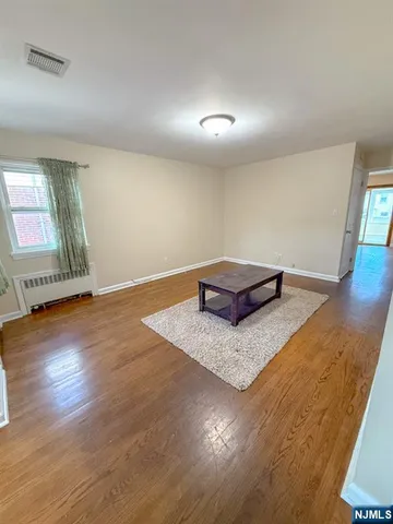 a view of a room with wooden floor and window