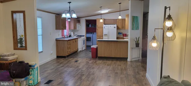 a kitchen with kitchen island wooden floor center island and stainless steel appliances
