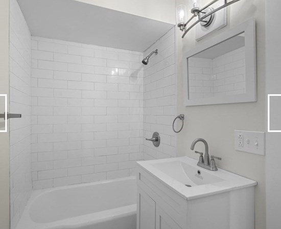 28 Borden Street, Unit 1 New Bedford, MA 02740 - Photo 6 of 11 a white bath tub sitting next to a white sink and vanity