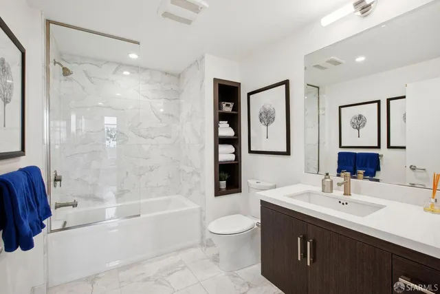 a bathroom with a bathtub shower sink mirror and toilet