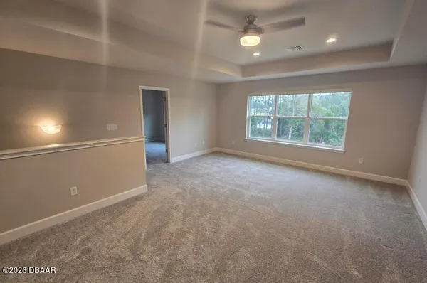 an empty room with a window and a fan