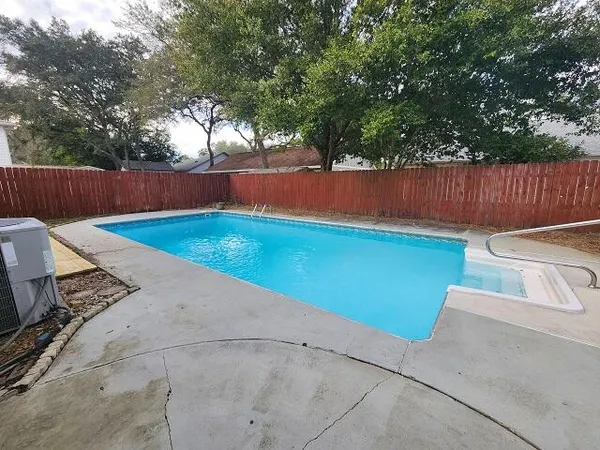a view of a backyard with lawn chairs and a large tree