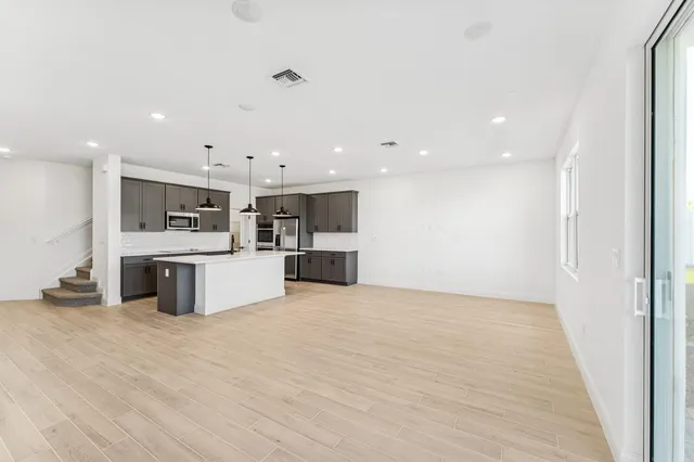 a large kitchen with stainless steel appliances kitchen island a large counter top and a stove top oven