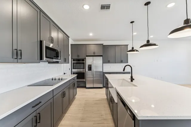 a kitchen with stainless steel appliances a sink stove and refrigerator