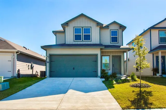 a front view of a house with a yard and garage