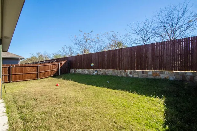 a view of backyard with wooden fence