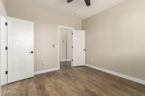 a view of a livingroom with a flat screen tv wooden floor and a ceiling fan
