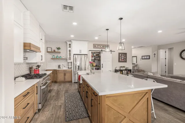 a kitchen with stainless steel appliances granite countertop a sink a stove and a refrigerator