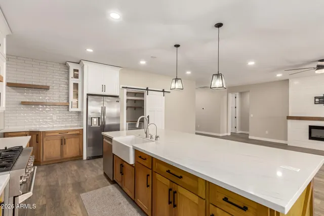 a view of a livingroom with a flat screen tv wooden floor and a ceiling fan