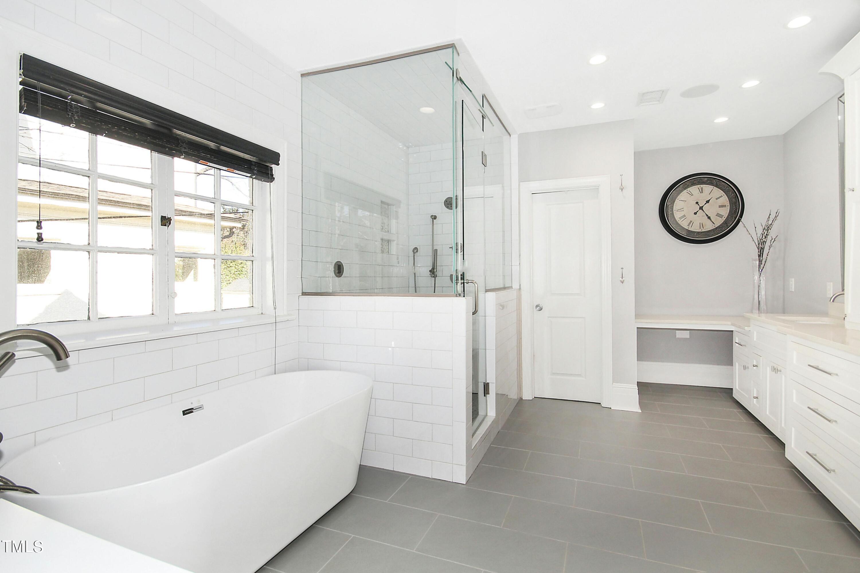 1512 Carr Street Raleigh, NC 27608 - Photo 23 of 60 a bathroom with a bathtub a sink and a large window