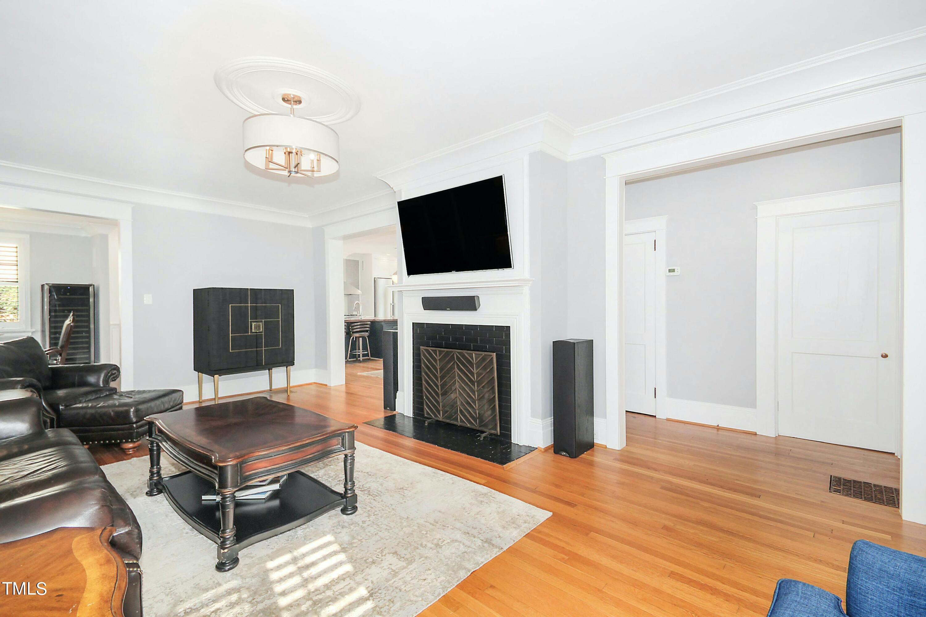 1512 Carr Street Raleigh, NC 27608 - Photo 5 of 60 a living room with furniture a flat screen tv and a fireplace