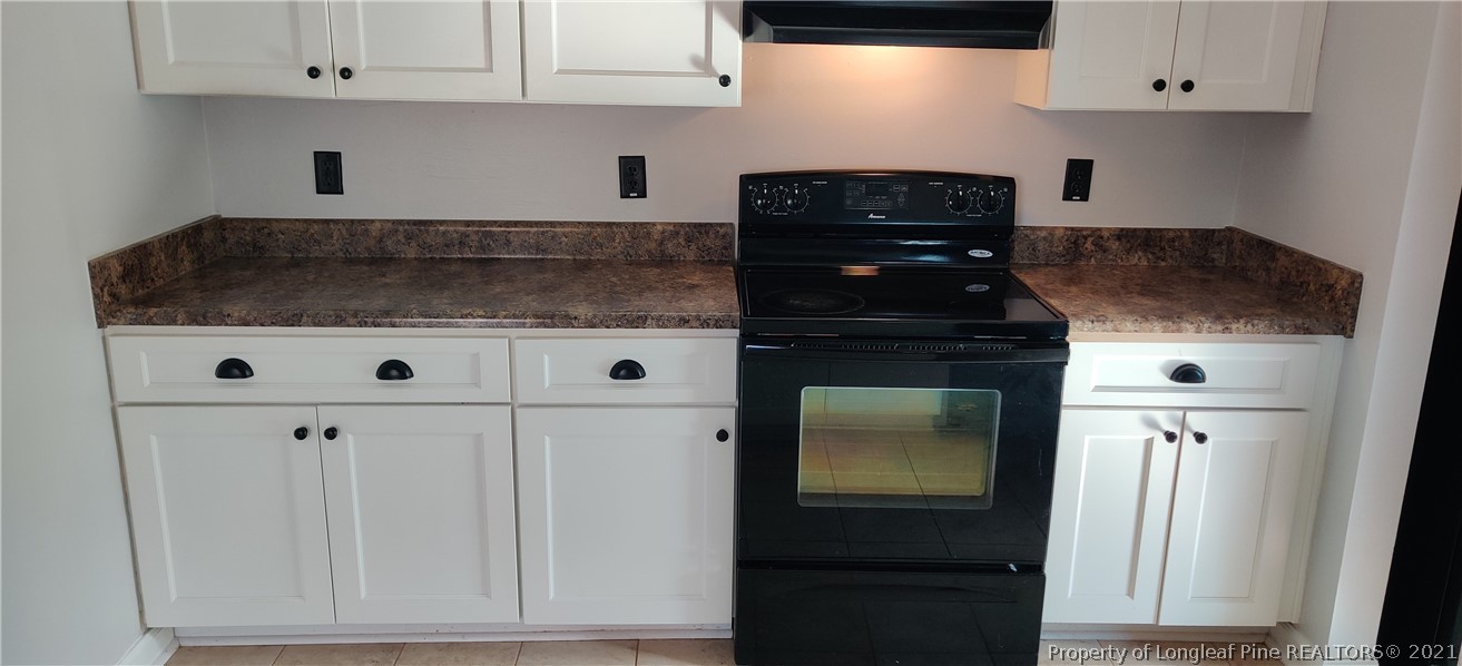 805 Rim Road Fayetteville, NC 28314 - Photo 8 of 20 a kitchen with white cabinets and black appliances