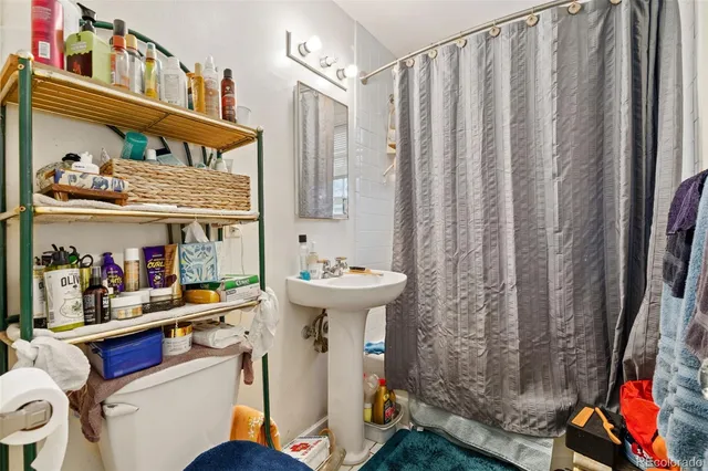a bathroom with a sink a toilet and shower curtain