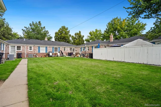 a view of a house with a big yard and large trees