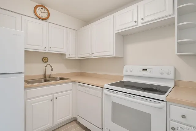 a kitchen with white cabinets and white appliances