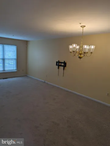 en empty room with windows and chandelier