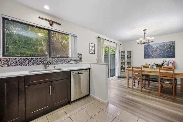 a view of kitchen with stainless steel appliances granite countertop sink stove dining table and chairs