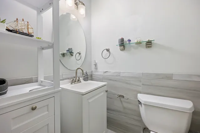 a bathroom with a granite countertop sink a toilet and a mirror