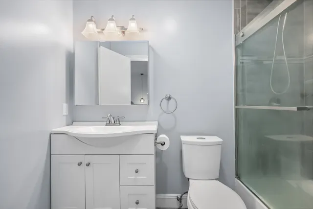 a bathroom with a sink mirror and toilet