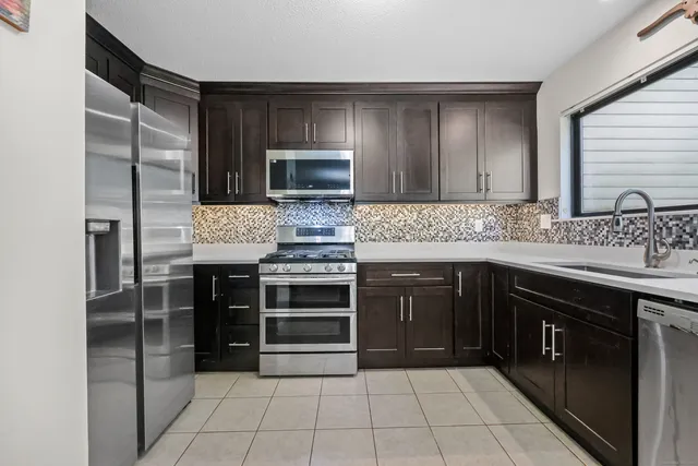 a kitchen with stainless steel appliances granite countertop a stove microwave and sink