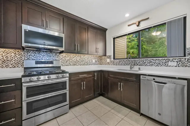 a kitchen with granite countertop cabinets stainless steel appliances and a sink