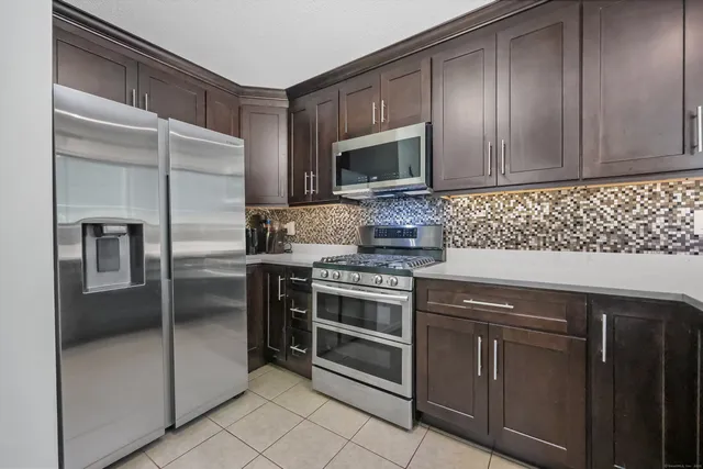 a kitchen with stainless steel appliances granite countertop a stove a microwave and a refrigerator