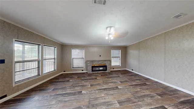 an empty room with windows fireplace and windows