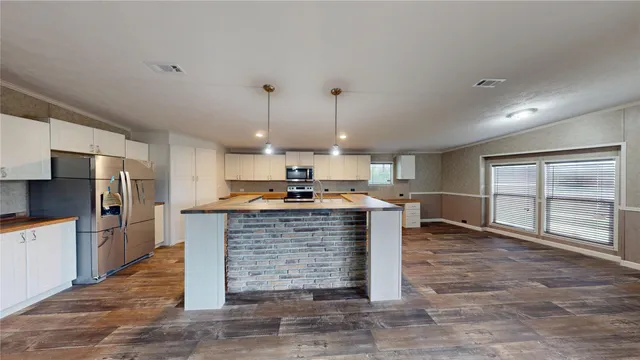 a kitchen with a refrigerator and a stove top oven