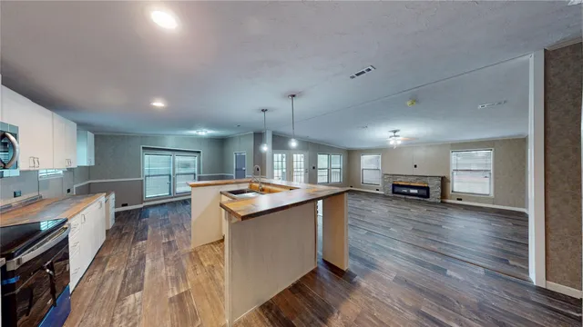 a large kitchen with a lot of counter space and wooden floor
