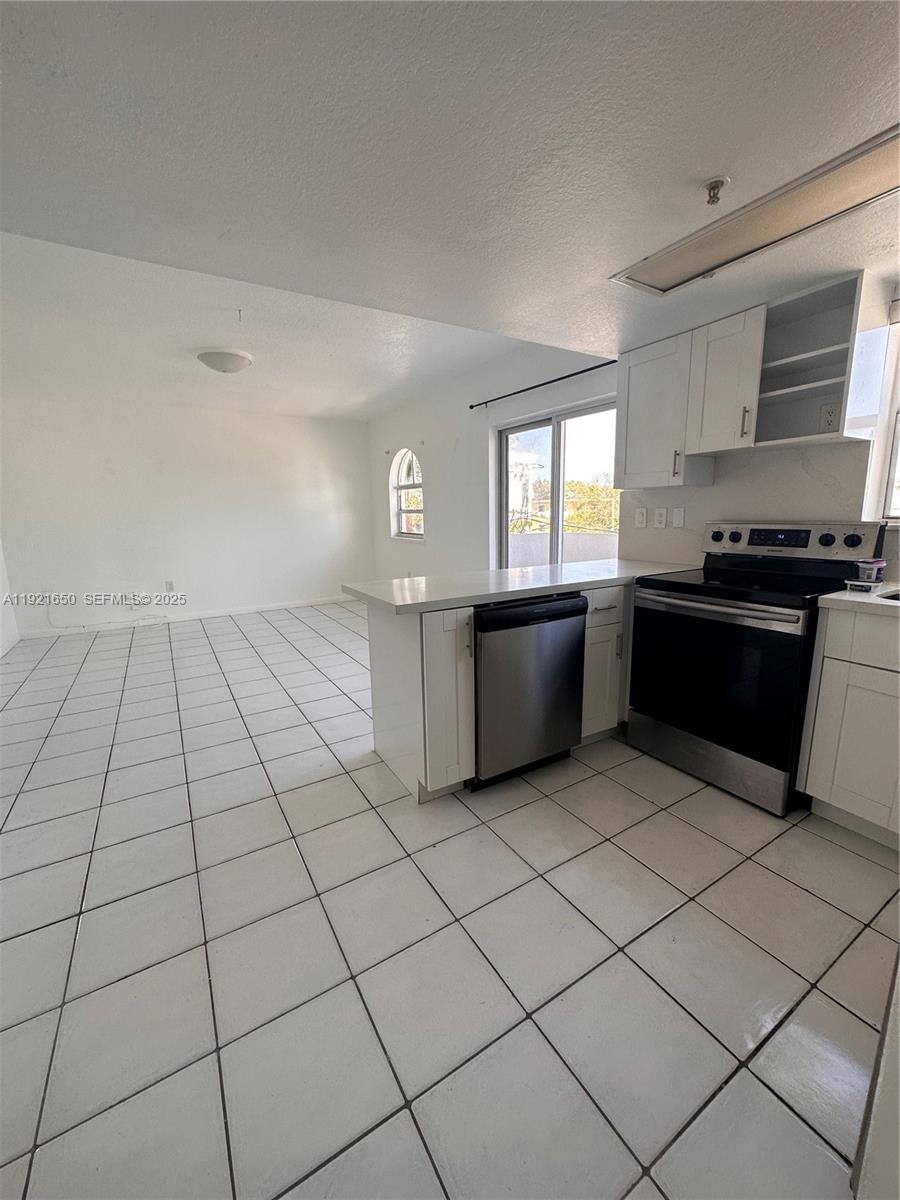 3052 Southwest 27th Avenue, Unit 301 Miami, FL 33133 - Photo 12 of 21 a kitchen with stainless steel appliances granite countertop a stove a sink and a refrigerator