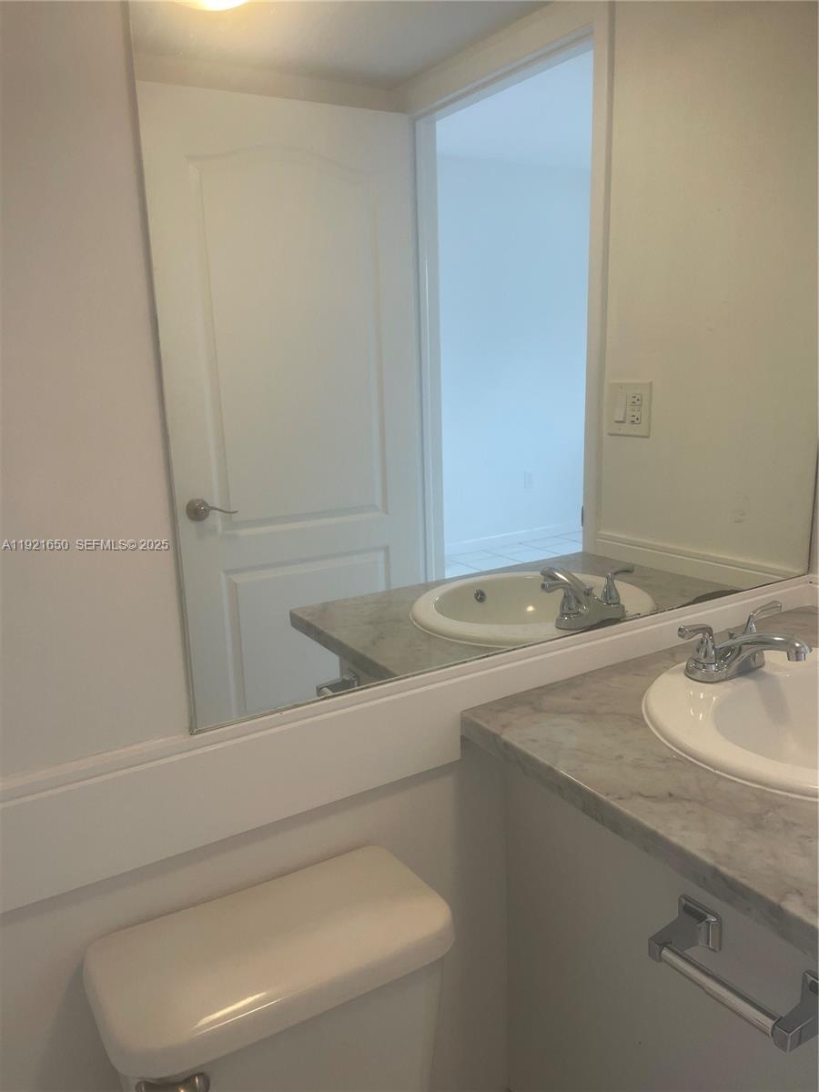 3052 Southwest 27th Avenue, Unit 301 Miami, FL 33133 - Photo 20 of 21 a bathroom with a sink and a mirror
