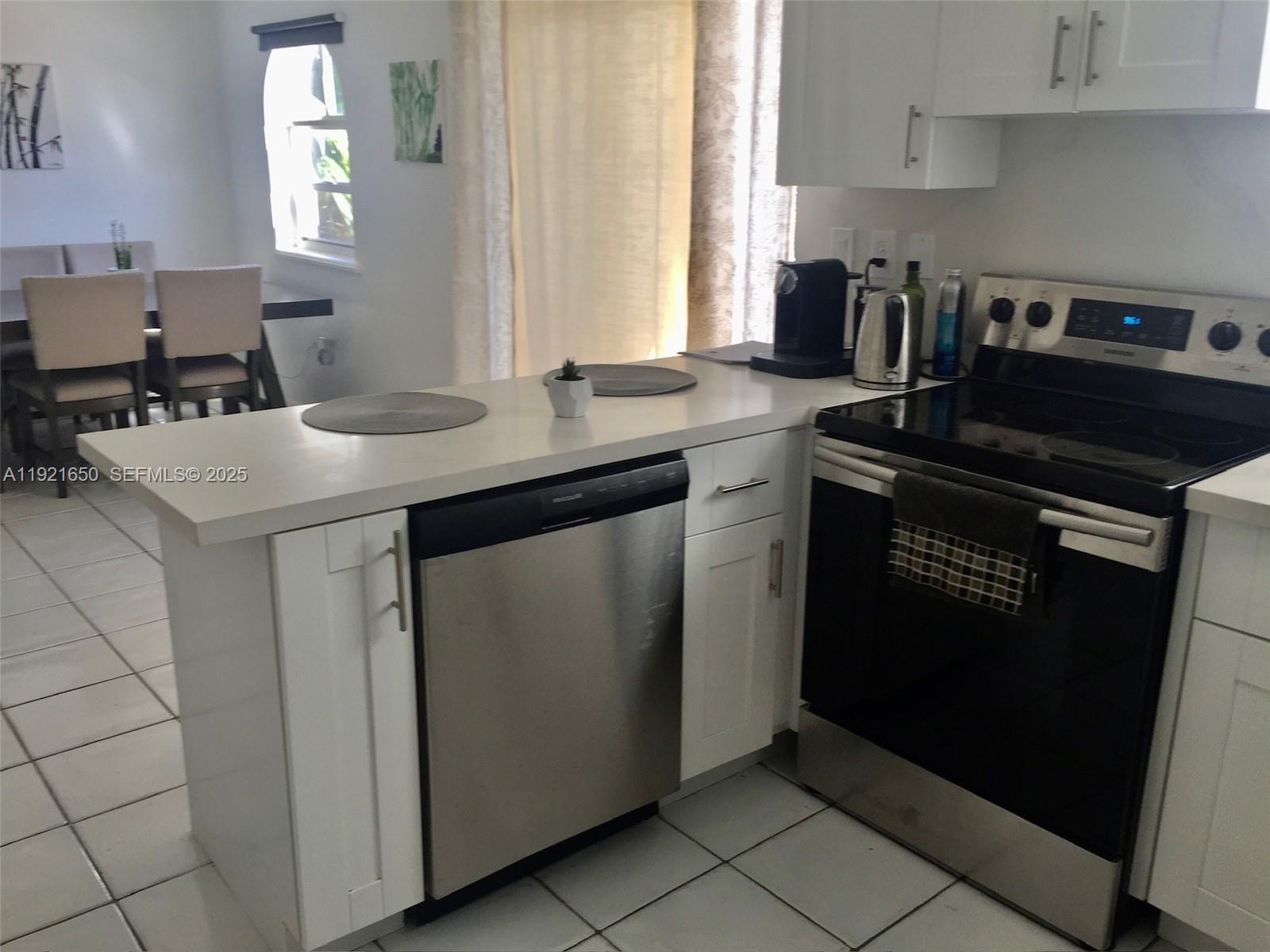 3052 Southwest 27th Avenue, Unit 301 Miami, FL 33133 - Photo 4 of 21 a kitchen with a sink cabinets and window