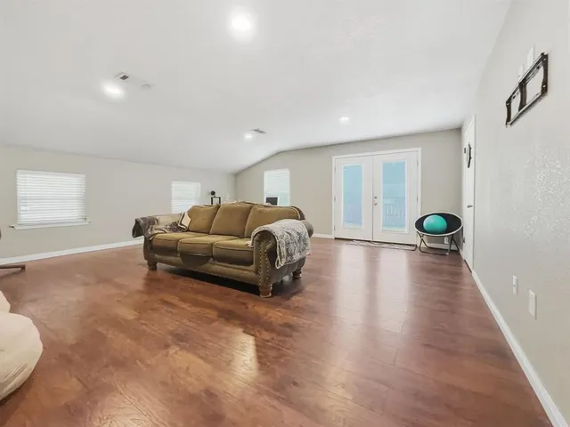 a living room with furniture and a wooden floor