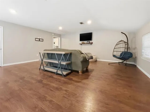 a living room with furniture a flat screen tv and gym equipment