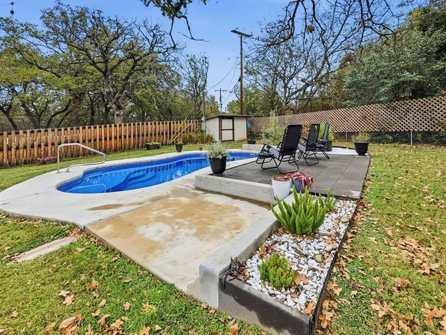 a view of backyard with swimming pool and seating